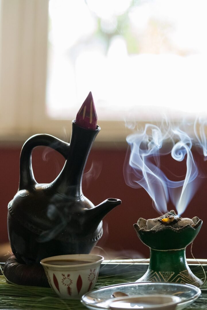 Coffee pot and incense with smoke rising.